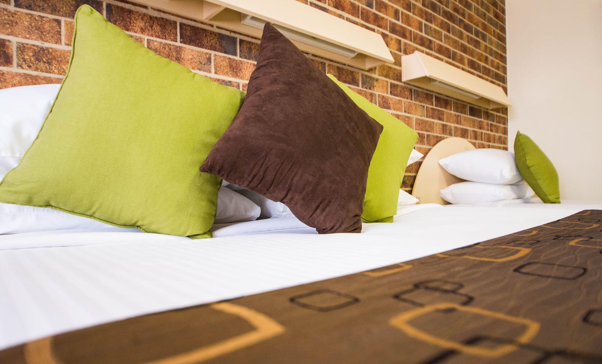 Crisp white bedding with patterned cushions, up close